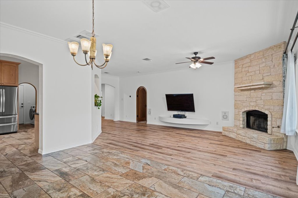 37 Pillow Road Austin, TX 78745 - Photo 4 of 18 A striking stone fireplace anchors this living space, offering warmth and a focal point.