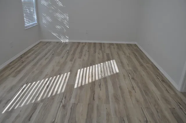 a view of empty room with wooden floor