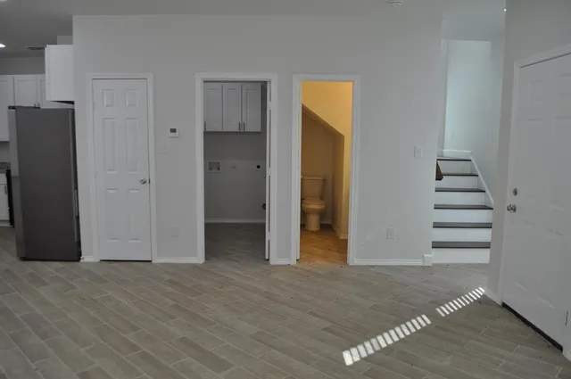 a view of a kitchen with refrigerator and wooden floor