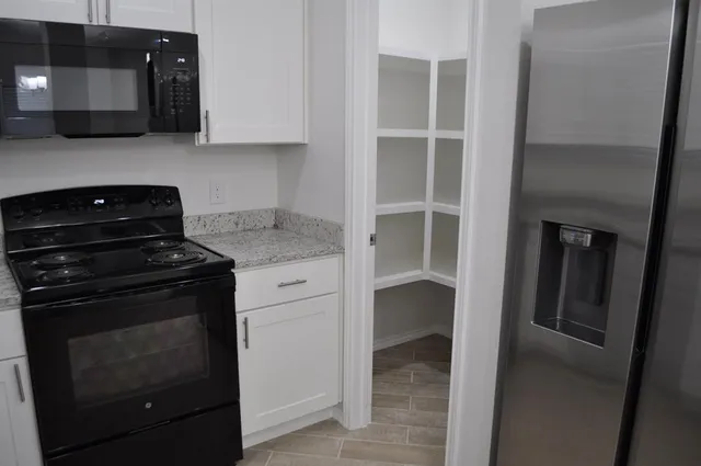 a bathroom with a granite countertop sink a mirror and vanity