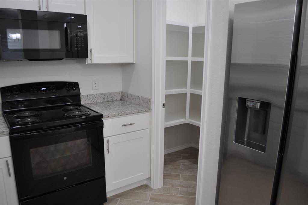 2321 Murphy Court Red Oak, TX 75154 - Photo 6 of 21 a kitchen with a stove and a microwave