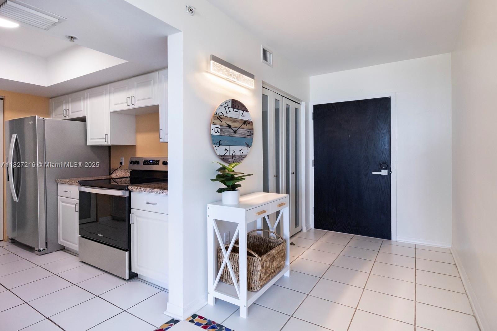 90 Alton Road, Unit 1005 Miami Beach, FL 33139 - Photo 13 of 22 a kitchen with stainless steel appliances kitchen island granite countertop a refrigerator and a stove