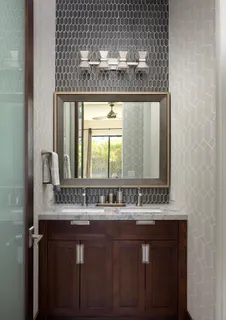 a view of a patio with couches table and chairs under an umbrella with large trees
