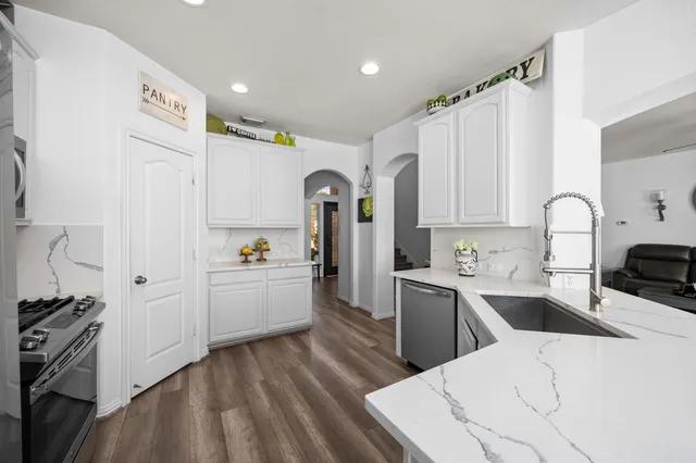a kitchen with a sink cabinets and wooden floor