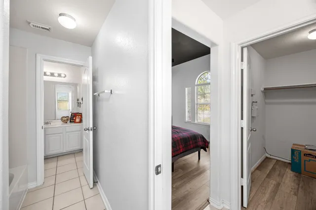 a bedroom with a bed a chair and a large window