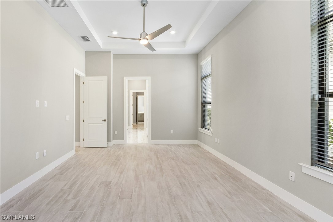 16257 Verilyn Circle Naples, FL 34110 - Photo 19 of 40 wooden floor in an empty room with a window