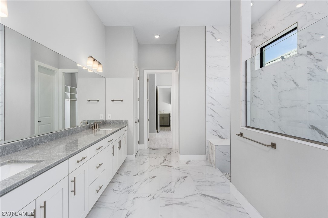 16257 Verilyn Circle Naples, FL 34110 - Photo 20 of 40 a spacious bathroom with a granite countertop sink a mirror and a shower