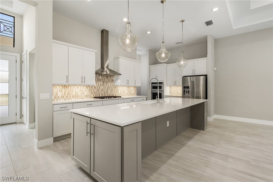 16257 Verilyn Circle Naples, FL 34110 - Photo 7 of 40 a kitchen with kitchen island a sink a stove and a refrigerator