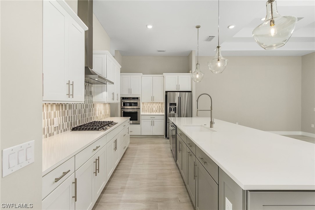 16257 Verilyn Circle Naples, FL 34110 - Photo 8 of 40 a kitchen with white cabinets appliances and sink