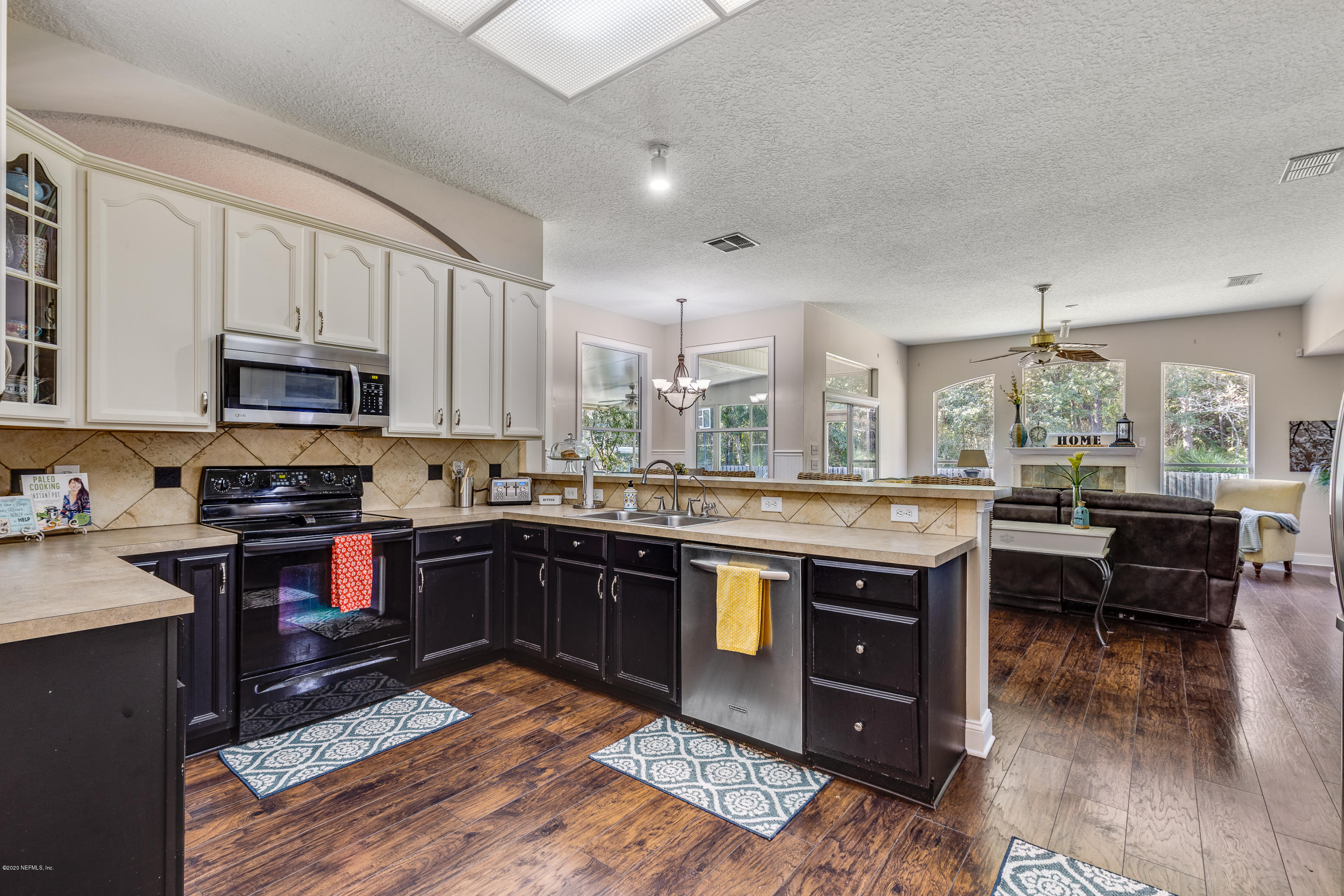 1798 Covington Lane Fleming Island, FL 32003 - Photo 11 of 30 a kitchen with stainless steel appliances granite countertop a stove top oven a sink dishwasher and wooden cabinets with wooden floor