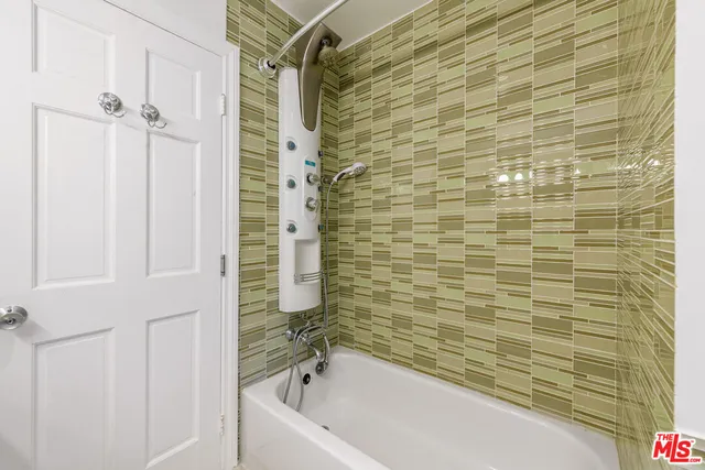 a bathroom with a granite countertop sink and a bathtub