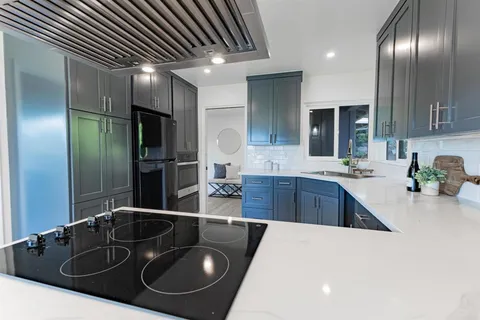 a kitchen with stainless steel appliances granite countertop a sink a stove and a refrigerator