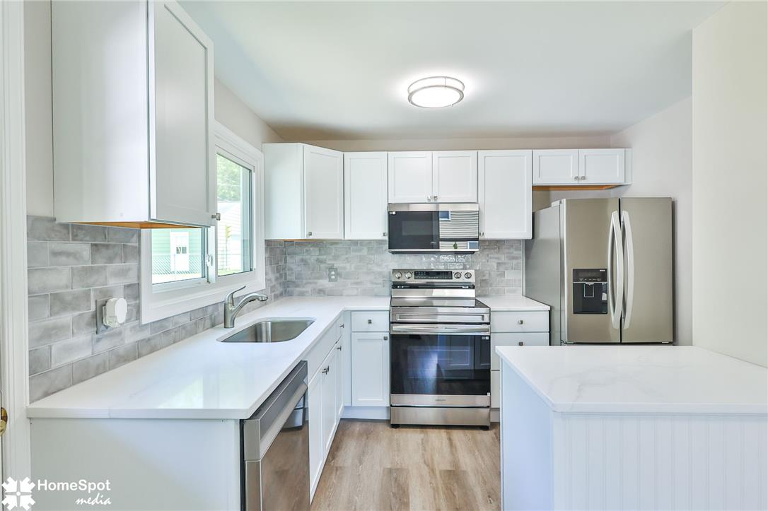 415 Willow Road Hellertown, PA 18055 - Photo 12 of 25 A sleek, contemporary kitchen with pristine white cabinetry and integrated stainless steel appliances.