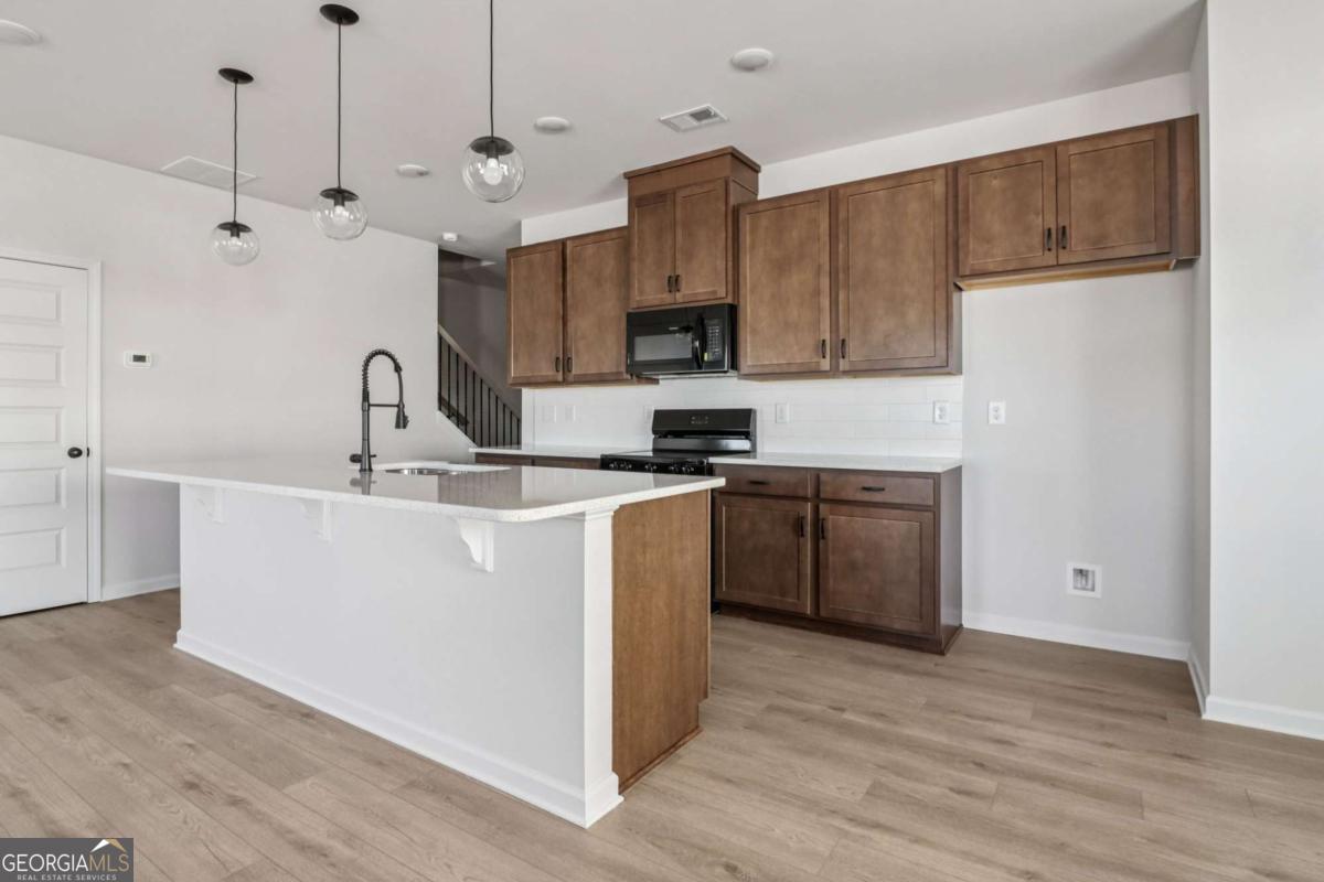 708 Shetland Trail Cartersville, GA 30121 - Photo 25 of 56 a kitchen with kitchen island a sink a stove a refrigerator and white cabinets