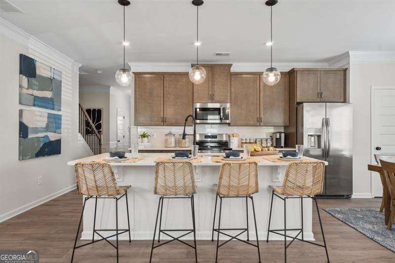 708 Shetland Trail Cartersville, GA 30121 - Photo 10 of 56 a kitchen with stainless steel appliances kitchen island granite countertop a dining table chairs and white cabinets