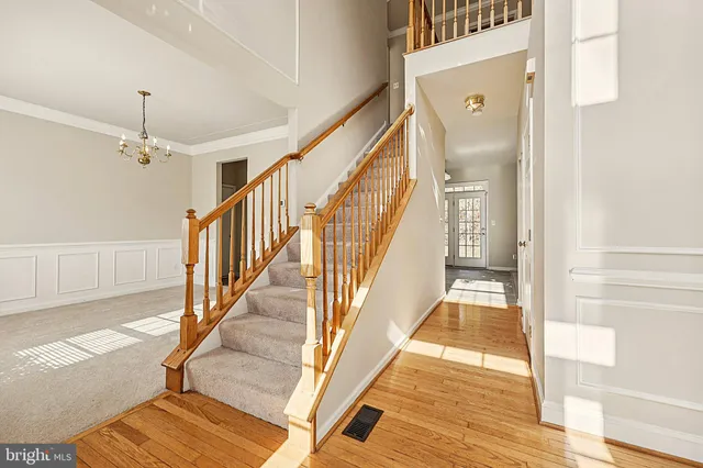 a view of a hallway with wooden floor and staircase