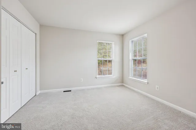 a view of empty room with wooden floor and ceiling fan