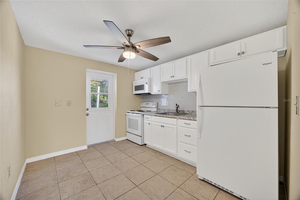 12337 Buffing Road, Unit A AND B Port Charlotte, FL 33981 - Photo 13 of 27 a kitchen with white cabinets and white appliances
