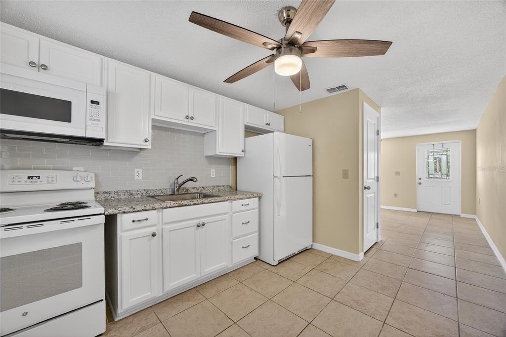 12337 Buffing Road, Unit A AND B Port Charlotte, FL 33981 - Photo 14 of 27 a kitchen with white cabinets and white appliances