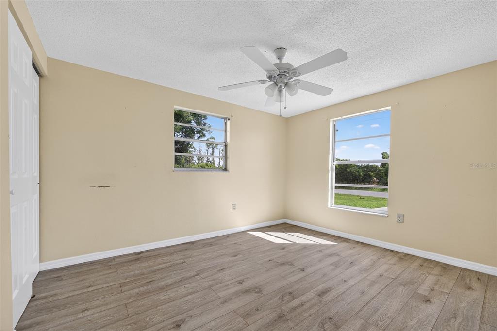 12337 Buffing Road, Unit A AND B Port Charlotte, FL 33981 - Photo 15 of 27 a view of a big room with wooden floor and windows