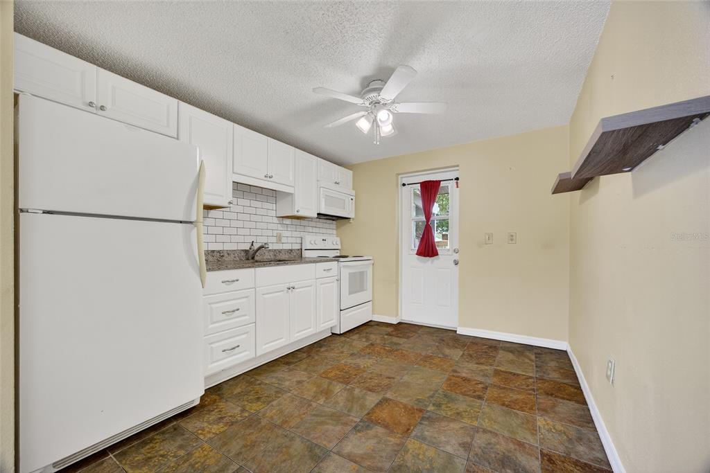 12337 Buffing Road, Unit A AND B Port Charlotte, FL 33981 - Photo 4 of 27 a kitchen with white cabinets and white appliances