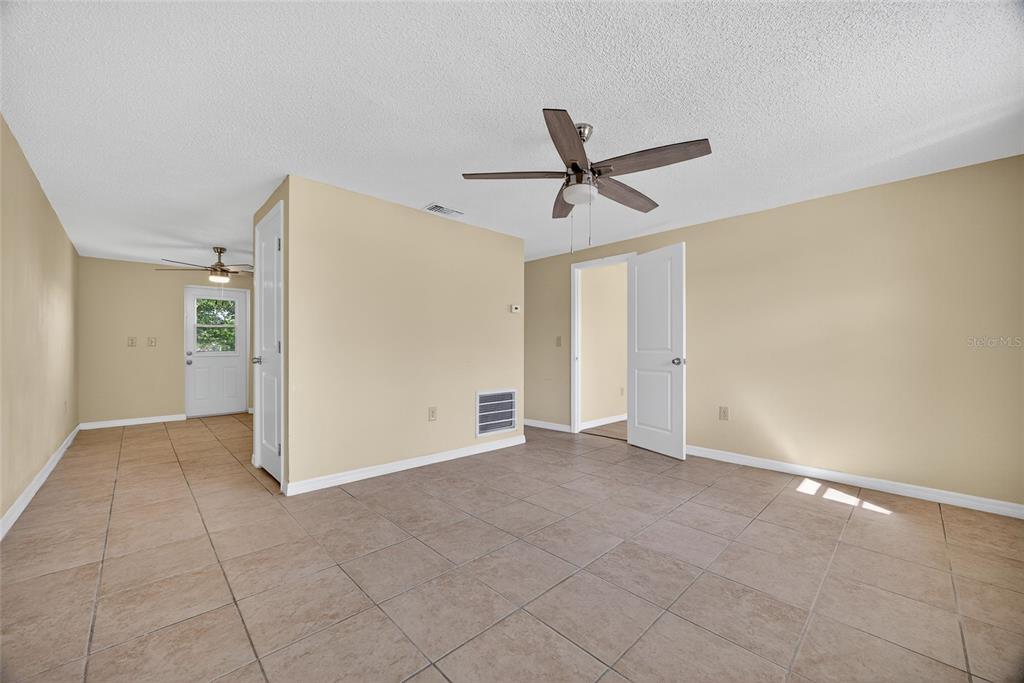 12337 Buffing Road, Unit A AND B Port Charlotte, FL 33981 - Photo 10 of 27 a view of empty room with wooden floor and ceiling fan