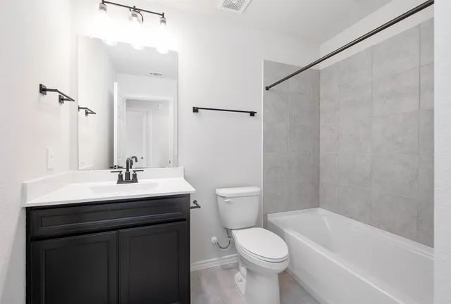 a bathroom with a sink a toilet a mirror and shower