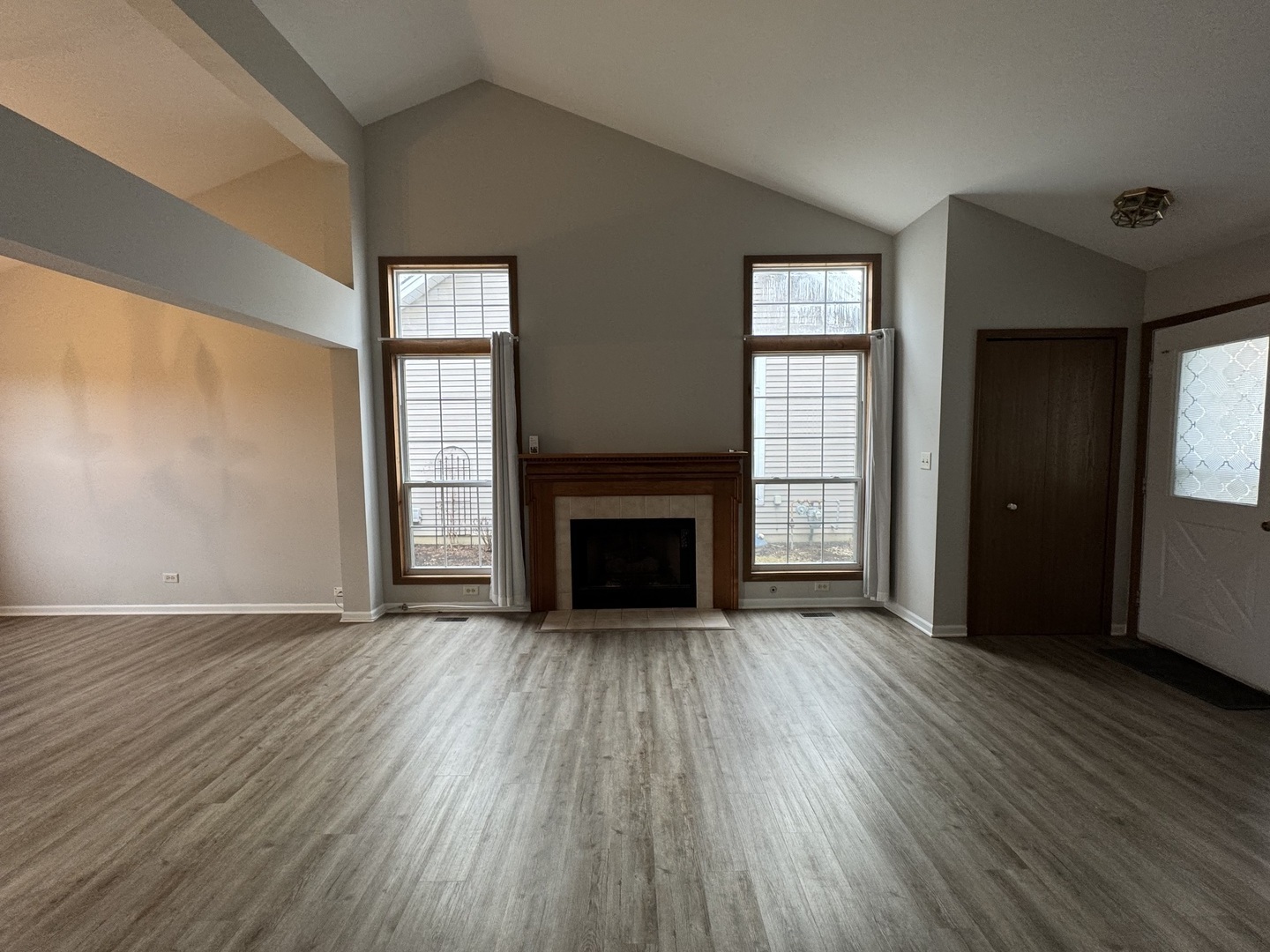 429 Prairieview Drive Oswego, IL 60543 - Photo 2 of 21 an empty room with wooden floor fireplace and windows