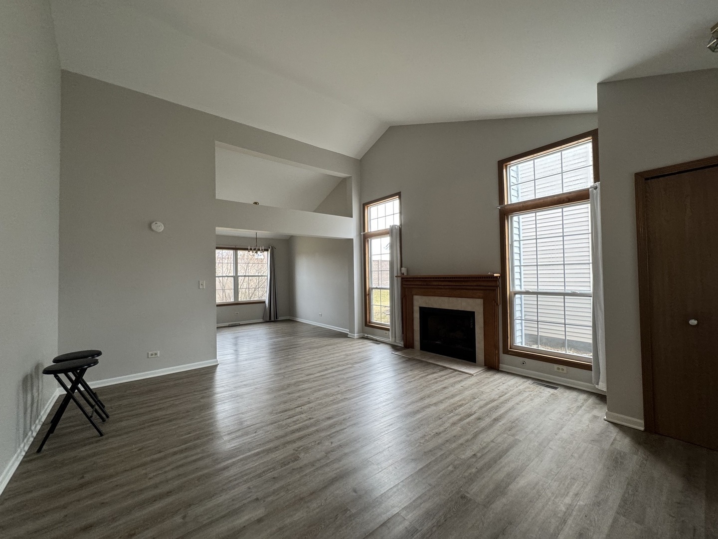 429 Prairieview Drive Oswego, IL 60543 - Photo 3 of 21 an empty room with windows fireplace and wooden floor