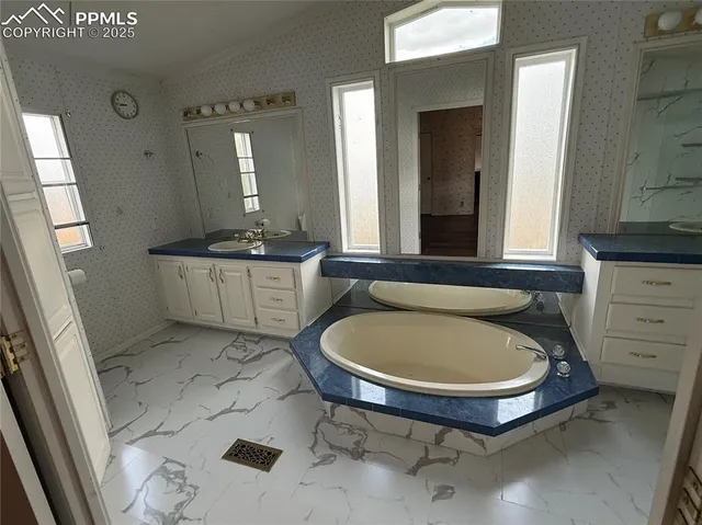 a bathroom with a sink a toilet a mirror and bathtub