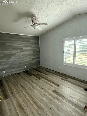 a view of a room with a ceiling fan and wooden floor