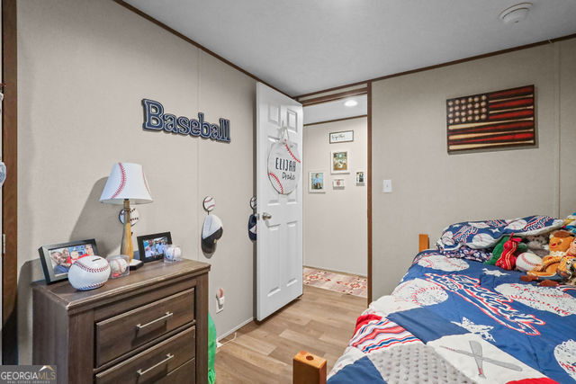 223 Primrose Lane Baxley, GA 31513 - Photo 17 of 27 a bedroom with a bed and wooden floor