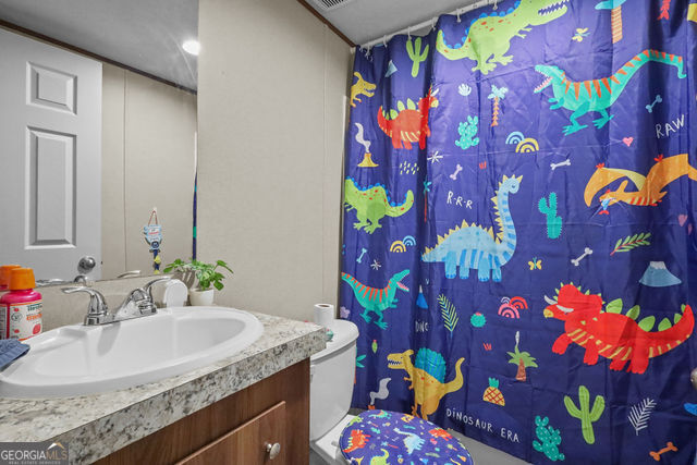 223 Primrose Lane Baxley, GA 31513 - Photo 18 of 27 a bathroom with a sink mirror and vanity