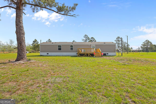 223 Primrose Lane Baxley, GA 31513 - Photo 23 of 27 a view of a lake with a building in the background