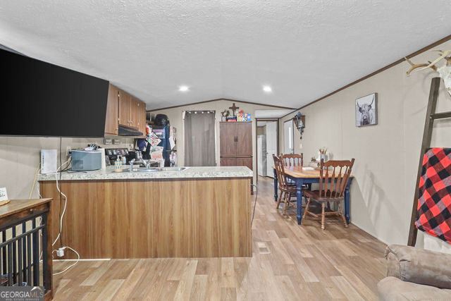 223 Primrose Lane Baxley, GA 31513 - Photo 6 of 27 a kitchen with stainless steel appliances granite countertop a sink table and chairs