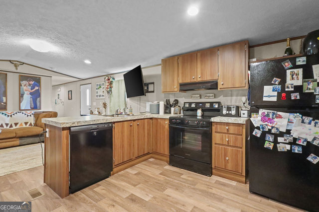 223 Primrose Lane Baxley, GA 31513 - Photo 8 of 27 a kitchen with stainless steel appliances granite countertop a stove sink and cabinets