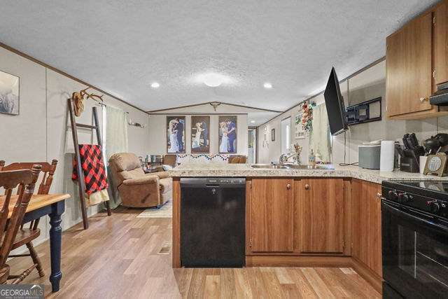 223 Primrose Lane Baxley, GA 31513 - Photo 9 of 27 a kitchen with stainless steel appliances granite countertop a sink dishwasher stove top oven and cabinets with wooden floor
