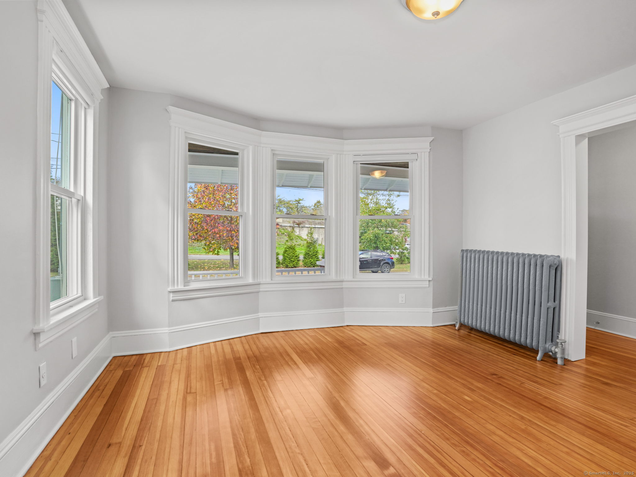 29 Redfield Road Fairfield, CT 06824 - Photo 4 of 37 an empty room with wooden floor and windows