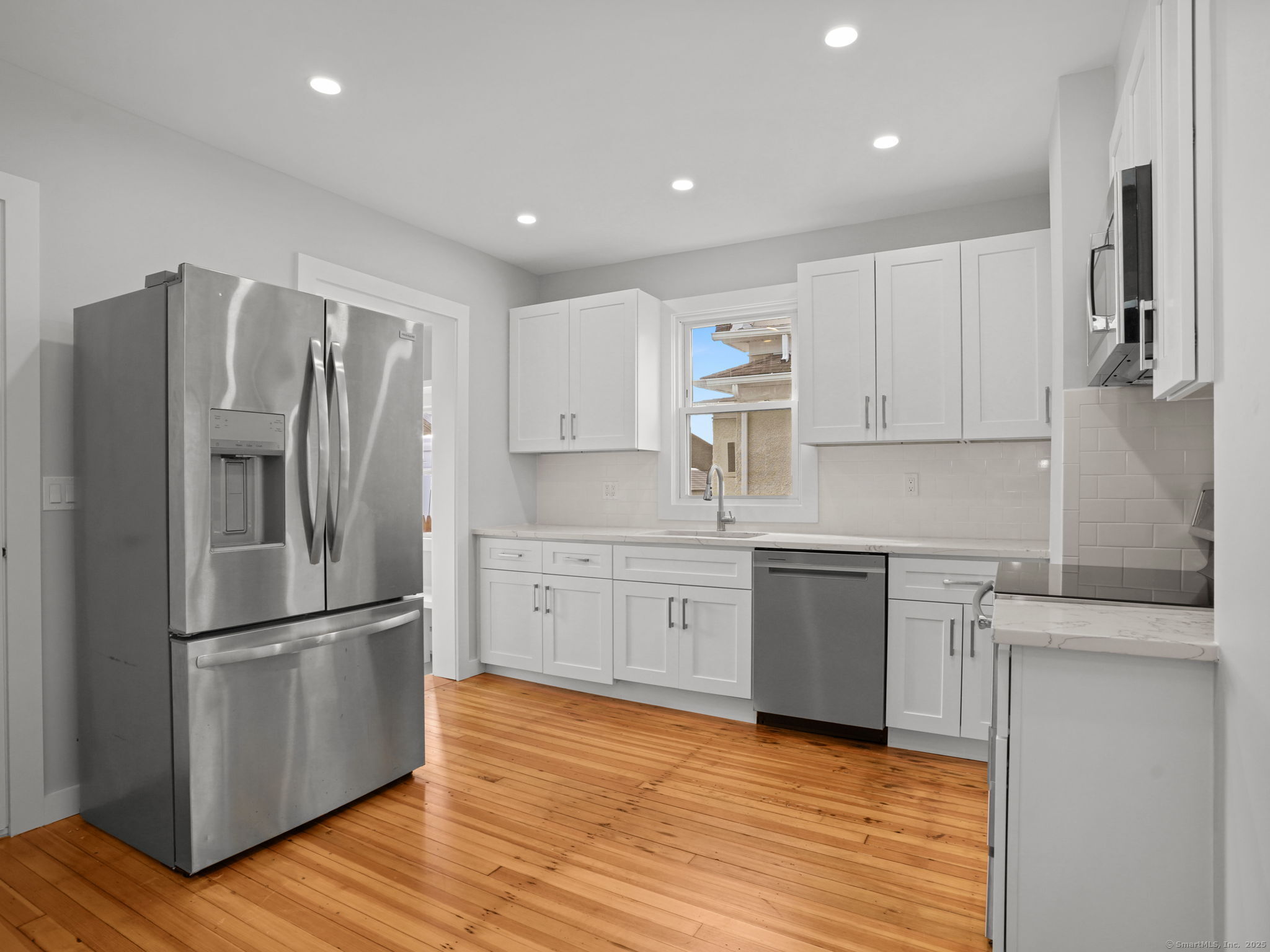 29 Redfield Road Fairfield, CT 06824 - Photo 7 of 37 a kitchen with a refrigerator stove top oven and cabinets