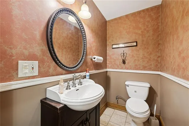 a bathroom with a toilet sink and mirror