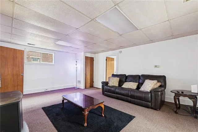 a living room with furniture a rug and a window