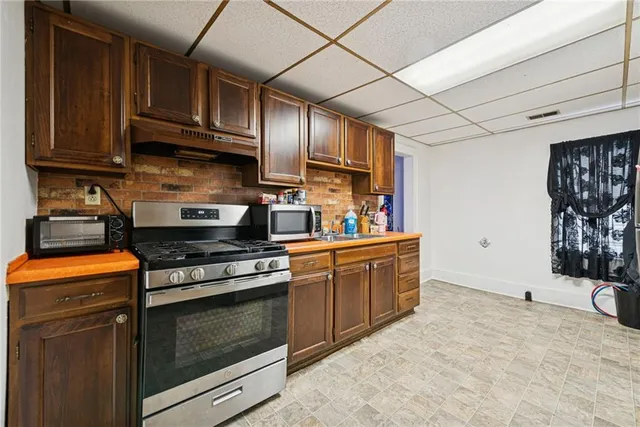 a kitchen with stainless steel appliances granite countertop a stove a sink and a microwave
