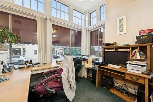 a view of a patio with lawn chairs and a barbeque