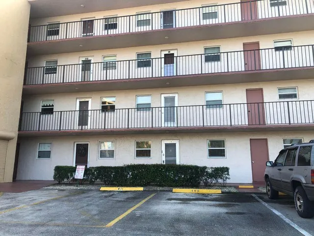 a front view of building with cars parked in front of it