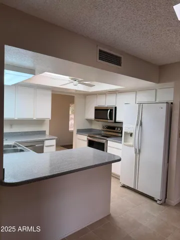a kitchen with granite countertop a refrigerator and a sink