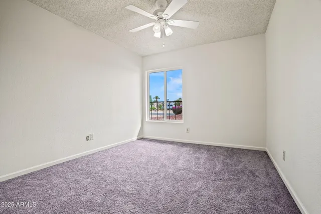 an empty room with fan and windows