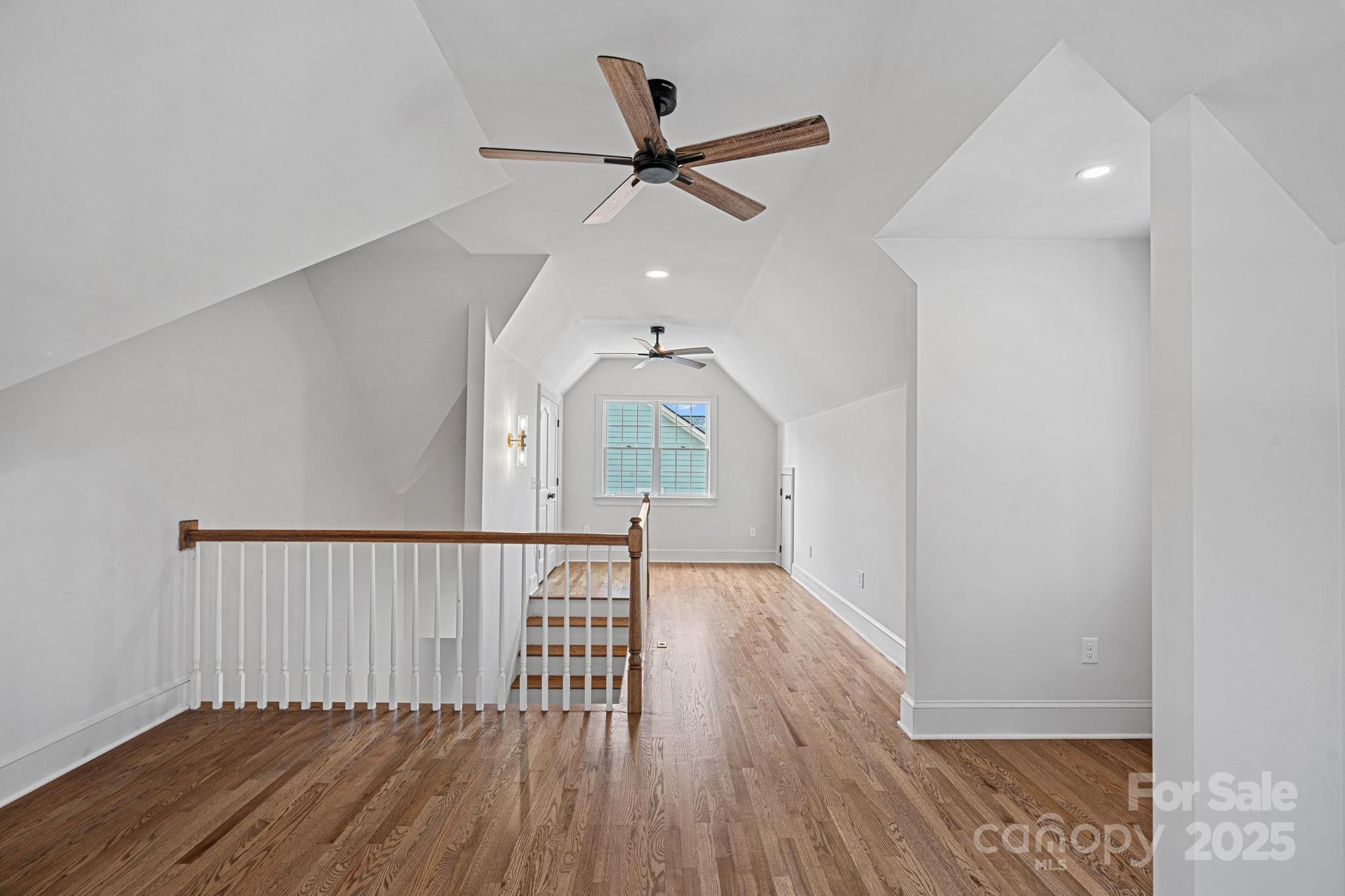 357 Magnolia Street Davidson, NC 28036 - Photo 45 of 48 a view of a hallway with wooden floor and a ceiling fan