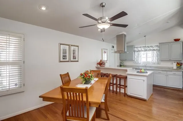 a kitchen with a dining table chairs and white cabinets