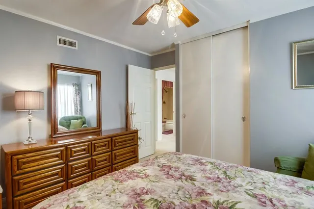 a bedroom with a bed and a large mirror on dresser