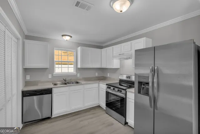a kitchen with a sink and stainless steel appliances
